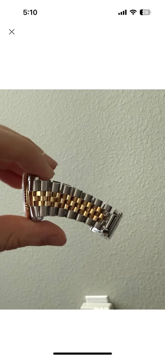 Two-tone Jubilee bracelet held in hand showing link stretch and clasp