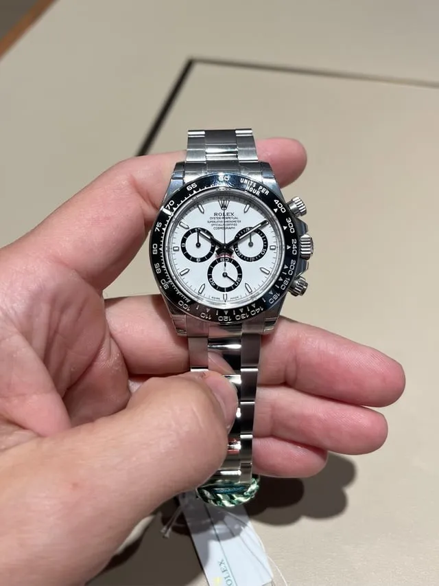 Rolex Daytona 126500LN panda dial held in hand, black ceramic bezel