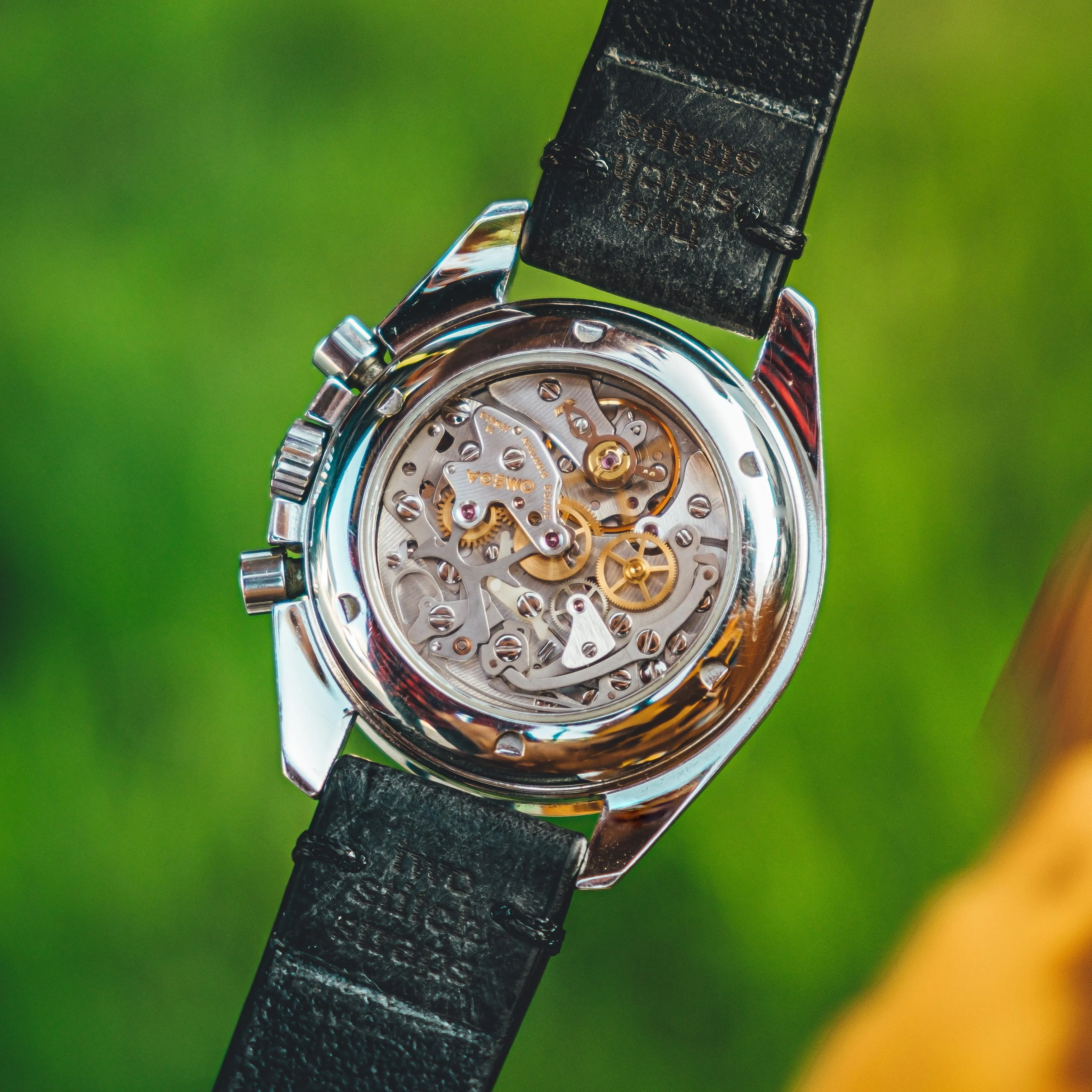 Omega Speedmaster exhibition caseback showing manual-wind movement with gold wheels and ruby jewels