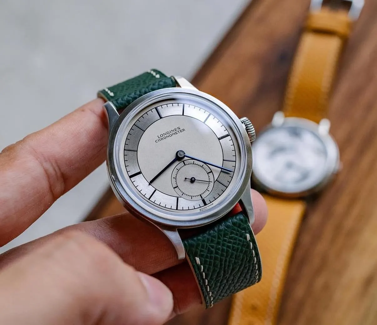 Longines Heritage Classic sector dial on green leather strap, held in hand