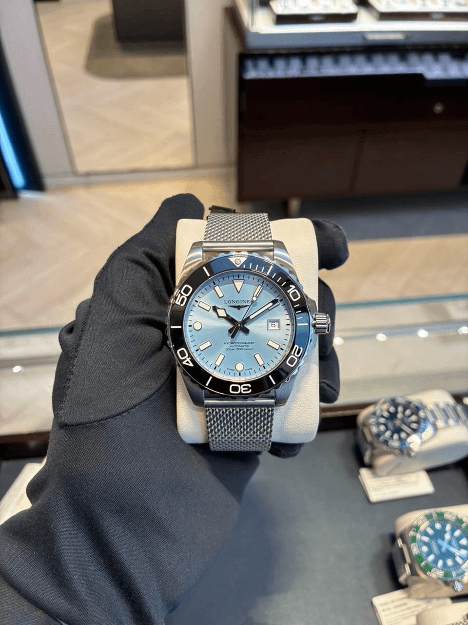 Longines HydroConquest ice-blue dial, black bezel, mesh bracelet, held on cushion