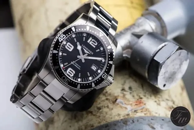 Longines HydroConquest black dial on steel bracelet resting on metal surface