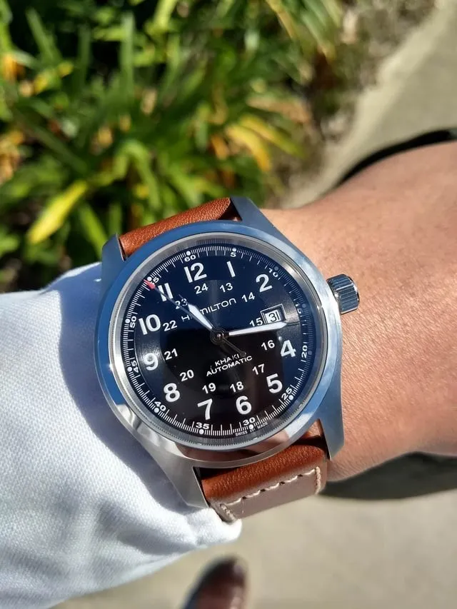 Hamilton Khaki Field Auto black dial on tan leather strap, worn on wrist outdoors