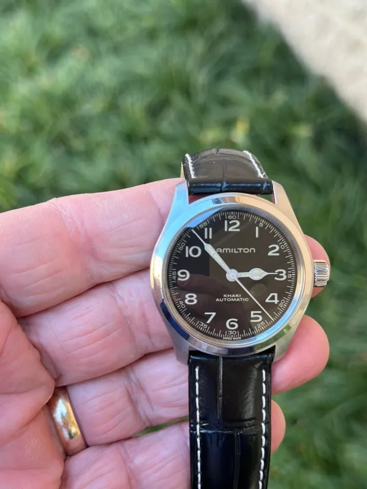 Hamilton Khaki Field Murph 38mm held in hand, black dial, black leather strap