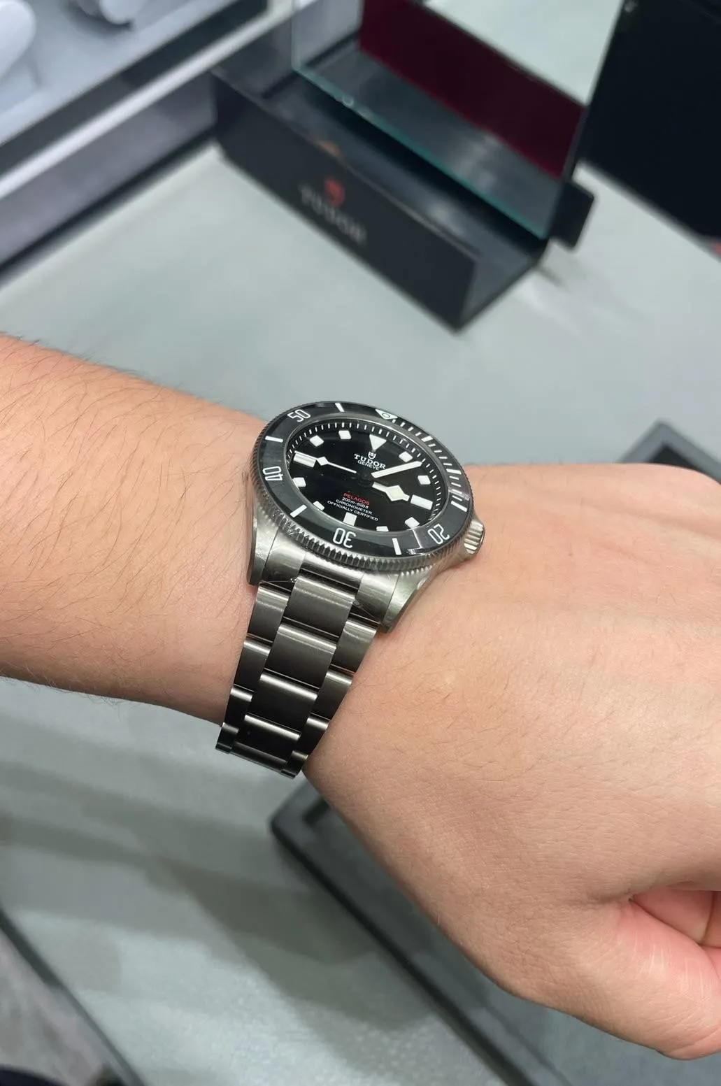 Tudor Pelagos black dial on steel bracelet worn on wrist in watch boutique