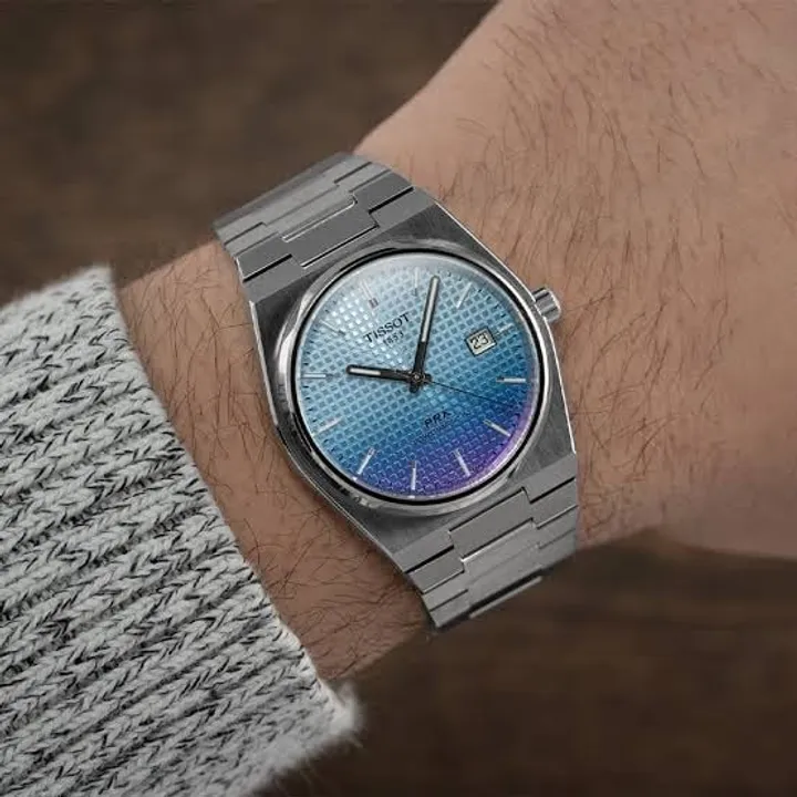 Tissot PRX Powermatic 80 light blue gradient dial on wrist, grey sweater