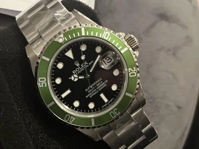 Rolex Submariner green ceramic bezel variant on dark display cushion