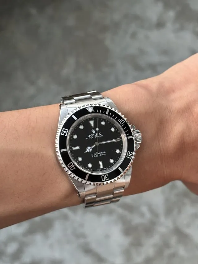 Modern no-date Rolex Submariner on wrist, lug overhang partially visible