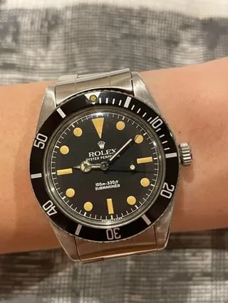 Vintage no-date Rolex Submariner with patinated gilt indices on wrist, Oyster bracelet.