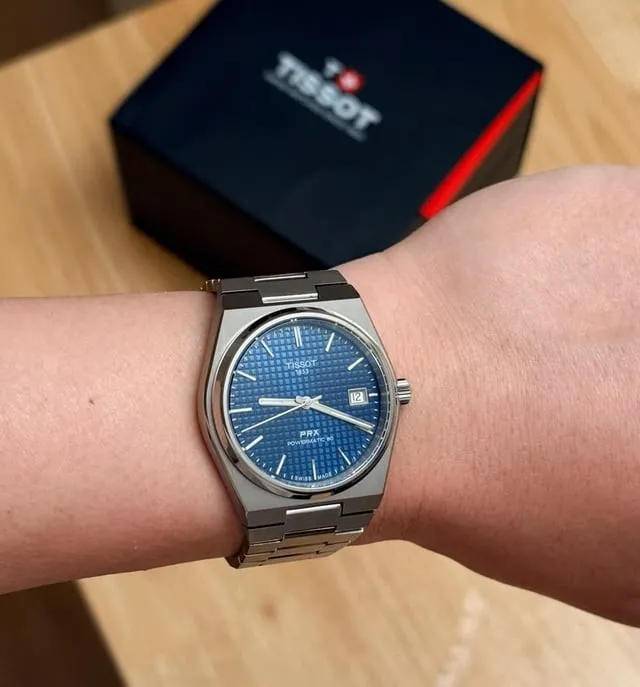 Tissot PRX blue dial on integrated stainless bracelet, wrist shot with box