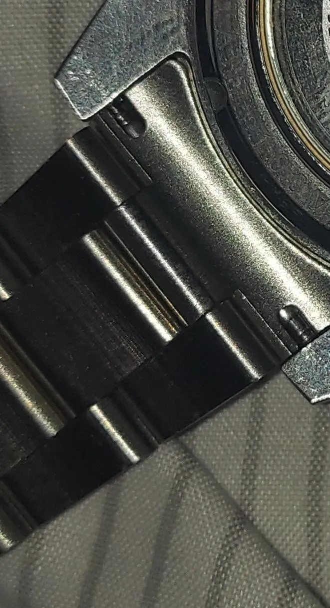 Macro close-up of dark PVD watch lug and bracelet end-link junction